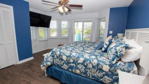 科罗拉126, Newmania- Semi-Oceanfront, Private Pool with Cabana! Ocean Views! Pool Table!的蓝色卧室配有床和吊扇