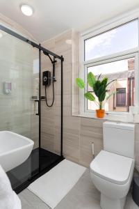 uma casa de banho com um chuveiro, um WC e um lavatório. em Flatzy - 12 Person Townhouse with Pool Table and Ping Pong em Liverpool