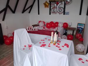 uma sala com duas mesas com corações vermelhos em Hospedaje mirador la Floresta em Santuario