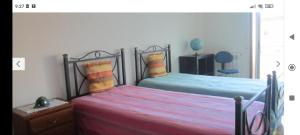 ヴィラ・ノヴァ・デ・ガイアにあるOceanView Apartment on Beach Near Portoのベッドルーム1室(ベッド2台、テーブル、椅子付)