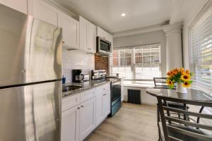 a kitchen with a stainless steel refrigerator and a table at Chic Newark Vacation Rental 3 Mi to Airport! in Newark