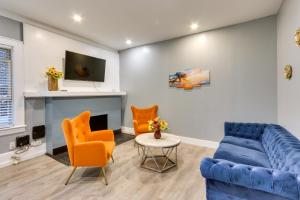 a living room with a blue couch and orange chairs at Chic Newark Vacation Rental 3 Mi to Airport! in Newark