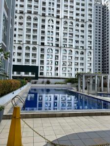 a swimming pool in front of a large building at eton emerald loft in Manila