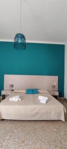 パレルモにあるIl クアドゥリフォリオ ルーム＆スイートの青い壁のベッドルーム1室(大型ベッド1台付)