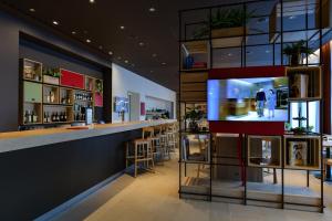 a bar in a restaurant with a tv on the wall at IntercityHotel Herford in Herford