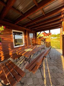 Cabaña de madera con mesa y bancos en el patio en Natura Dom Iwona Przybysz, en Kaplityny