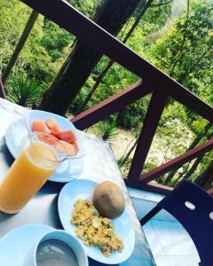 einen Tisch mit Teller mit Lebensmitteln und ein Glas Orangensaft in der Unterkunft Finca Hotel Spa Zhay in Tibirita