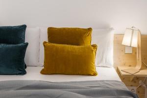 1 cama con almohadas blancas y almohada amarilla en BNBHolder Modern Loft III Centre, en Madrid