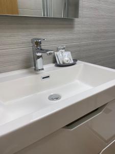 un lavandino bianco del bagno con rubinetto di Barista Homes a San Miguel de Abona