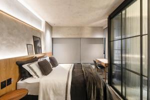 a bedroom with a bed and a desk in a room at Studio London in Campo Grande +2 photos