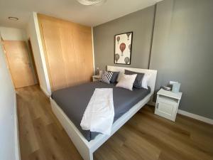 een slaapkamer met een bed en een houten vloer bij Barista Homes in San Miguel de Abona +139 foto's