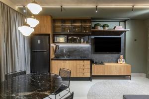 a kitchen with a black refrigerator and a table at Studio London in Campo Grande