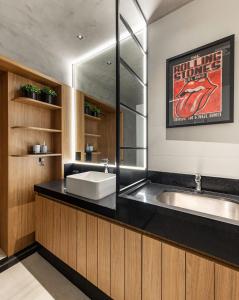a bathroom with a sink and a large mirror at Studio London in Campo Grande