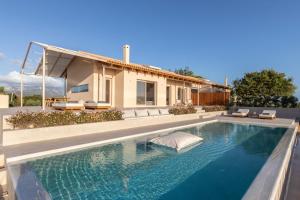 a swimming pool in front of a house at AVERTOSIA Luxury Villas in Argostoli