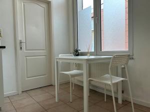 einen Tisch und zwei Stühle in einem Zimmer mit Fenster in der Unterkunft Laeken : Cocon Chaleureux & Confort in Brüssel