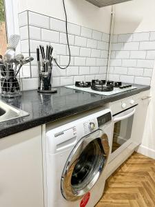 a kitchen with a washing machine under a counter at Spacious Town House in Wyken
