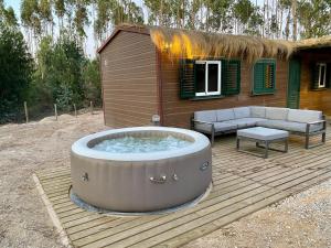a hot tub on a wooden deck with a house at Montum Farm Living in Melides