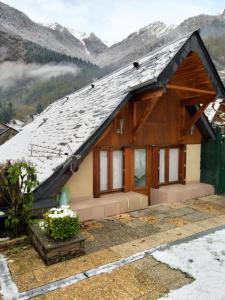 una casa en las montañas con nieve en el techo en petite maison de montagne avec jardin, en Cier-de-Luchon