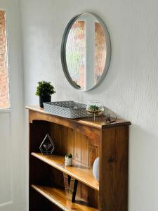 a mirror on top of a wooden shelf in a room at Spacious Town House in Wyken