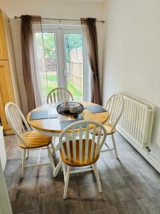 een eetkamer met een tafel en stoelen en een raam bij Spacious Town House in Wyken