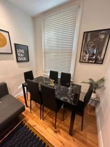 a dining room with a glass table and chairs at Notting Hill Guest Flat in Ealing
