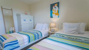two beds sitting next to each other in a room at Gwyndy Bach in Trearddur