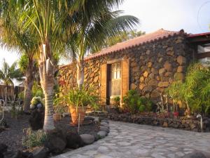 uma casa de pedra com palmeiras em frente em Finca del Sur em Las Indias