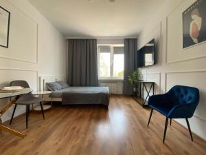 a bedroom with a bed and a table and chairs at Apartament WHITE in Kielce