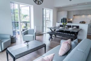 a living room with a couch and a table and a kitchen at The Sidings, Luxury Penthouse, Haworth in Haworth