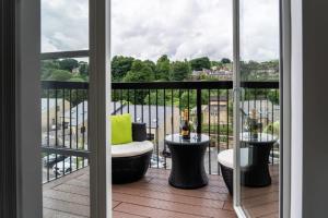 a balcony with a chair and tables on a balcony at The Sidings, Luxury Penthouse, Haworth in Haworth