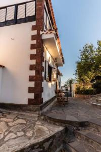 a brick building with a bench next to a house at Casa Niebla - Zona Rural - Alajeró in Alajeró