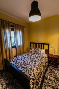 um quarto com uma cama com um edredão azul e um candeeiro em Casa Niebla - Zona Rural - Alajeró em Alajeró