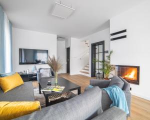 a living room with a couch and a fireplace at Dom Marina Mosty, Sauna Hot Tub Holiday Home near Rewa Gdańsk in Mosty