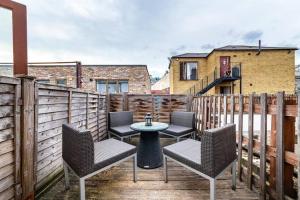 a patio with chairs and a table on a deck at Lovely 2 BR with patio Waterloo LM1 in London