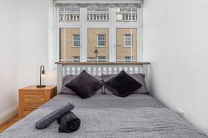 a bedroom with a bed with a large window at Lovely 2 BR with patio Waterloo LM1 in London