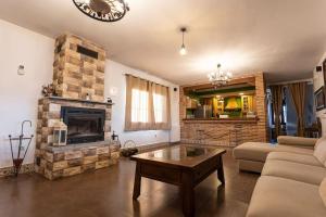 a living room with a couch and a fireplace at Casa Rural El Abuelo Mauri 4* En Toledo in Mascaraque