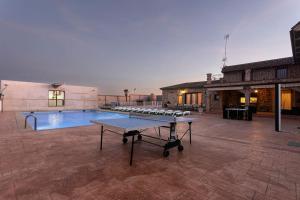 un tavolo da ping pong in un cortile con piscina di Casa Rural El Abuelo Mauri En Toledo a Mascaraque