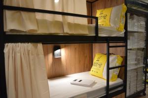 a bunk bed with a book and a yellow bag on it at Hostel del Templo de Debod in Madrid