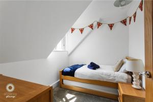 ein Schlafzimmer mit einem Bett und einem Tisch mit einer Lampe in der Unterkunft The Lookout in Hythe