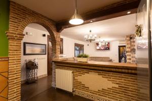 una cucina con muro di mattoni e camino di Casa Rural El Abuelo Mauri En Toledo a Mascaraque