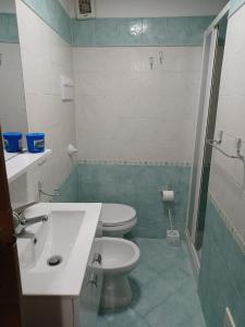 uma casa de banho com um lavatório branco e um WC. em La Casa di Anna em Bagheria