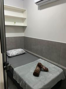 une paire de chaussures assise sur un lit dans une pièce dans l'établissement Phos Hostel, à Araxá