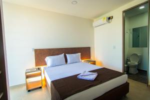 um quarto com uma cama grande com uma mesa de cabeceira e uma cama sidx sidx sidx em HOTEL EL NARANJO em Acacías