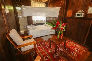 1 dormitorio con 1 cama, 1 mesa y 1 silla en Sandoval Lake Lodge, en Puerto Maldonado