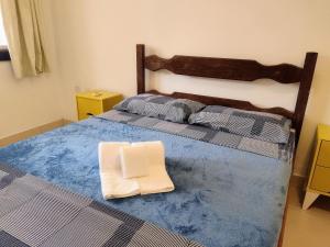 a bed with two towels sitting on top of it at Casa com garagem - 300m da Rua das Pedras in Búzios