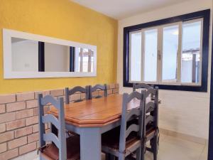 a dining room with a wooden table and chairs at Casa com garagem - 300m da Rua das Pedras in Búzios