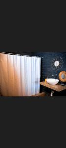 baño con lavabo y cortina de ducha en Mahalo Lobitos, en Lobitos