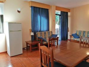 a dining room with a table and chairs and a refrigerator at Casa Carolina 2 in Playa de Santiago