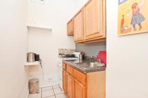 una pequeña cocina con armarios de madera y fregadero en great studio apt new york city, en Nueva York