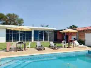 a pool with chairs and tables and umbrellas at ALOJAMIENTO ASPEN HOME in San Lorenzo de la Frontera